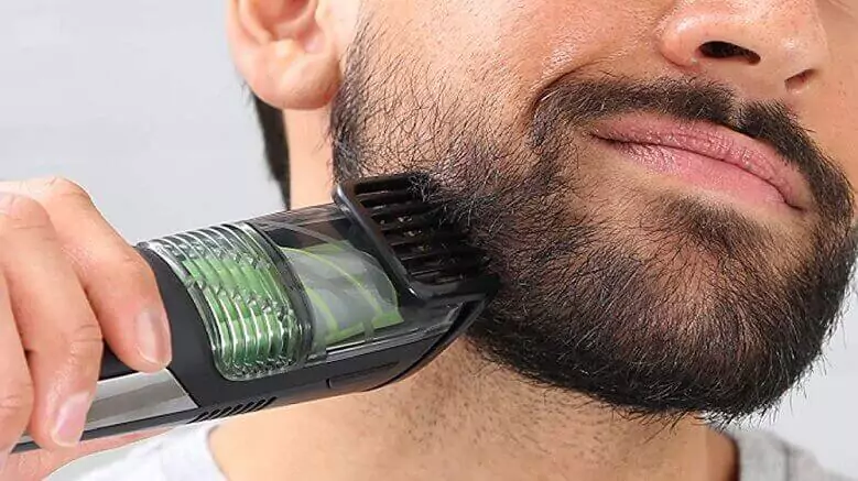 Imagem destacada do post sobre o melhor aparador de barba: Foco em homem barbudo utilizando um aparador verde e preto