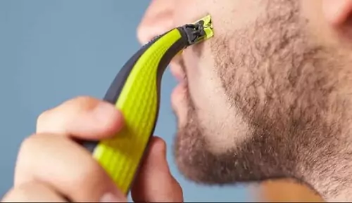 Homem utilizando OneBlade para raspar uma faixa de barba.