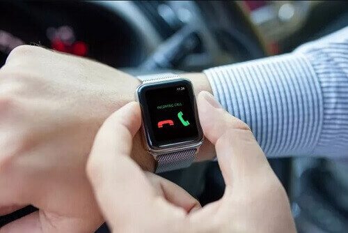 Foco em smartwatch sendo usado para atender uma chamada telefônica.