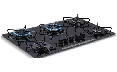 Cooktop 5 bocas com mesa de vidro preta, com queimador rápido ao centro, detalhe em branco na borda e manípulos centrais.