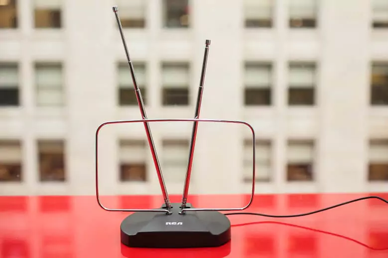 Abertura do post sobre a melhor antena digital interna: antena com duas antenas em cima de mesa vermelha.
